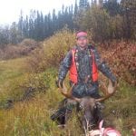 Man posing with a bull moose