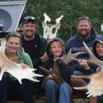 Family posing with bull mooose rack