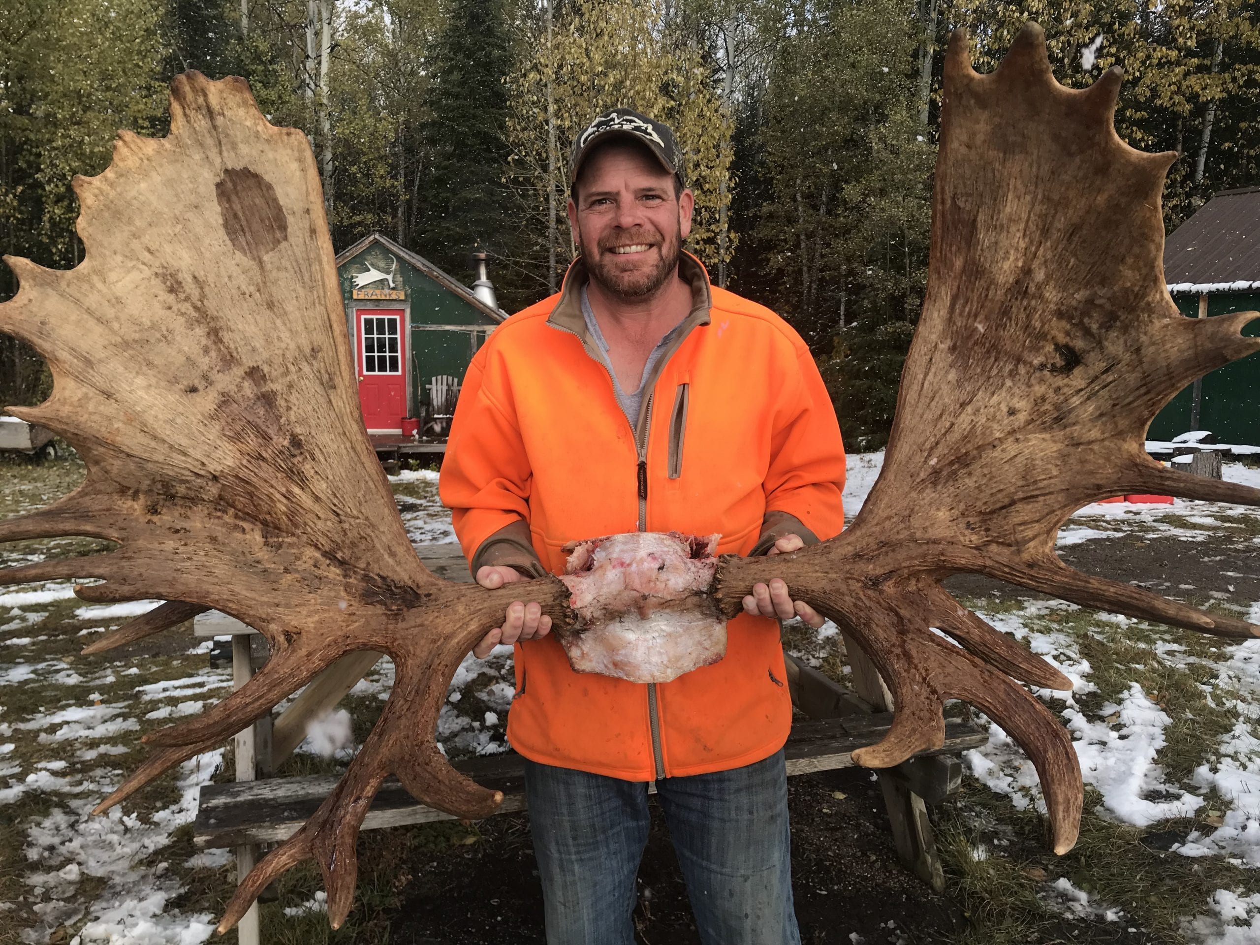 Man posing with a bull moose rack