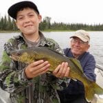 Father and son posing with a walleye catch
